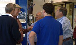 Sporty's Founder and Owner Hal Shevers, left in hat, and AOPA President Craig Fuller, checkered shirt at right, talk with a group of fly-in attendees.