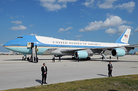 Secret Service agents flank Air Force One as members of the presidential entourage deplane.