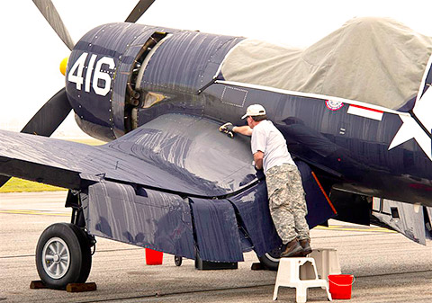 Jim Tobul wipes down the Chance Vought F4U-4 Corsair in which his father died