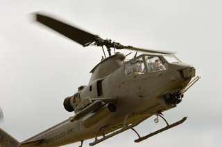 Above the flightline the Cobra maneuvers for landing.