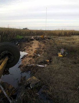 NTSB photo of an agricultural aircraft accident scene with a MET visible in the background. 