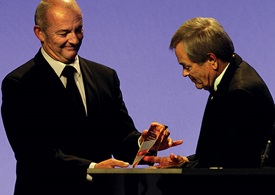 Mike Houghton, right, accepts the inaugural ICAS Wingman award from Breitling Jet Team founder and leader Jacques Bothelin during the ICAS convention in December. Marc St. Pierre photo courtesy of the International Council of Air Shows.