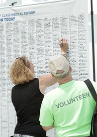 A visitor signs the medical petition at the AOPA tent.
