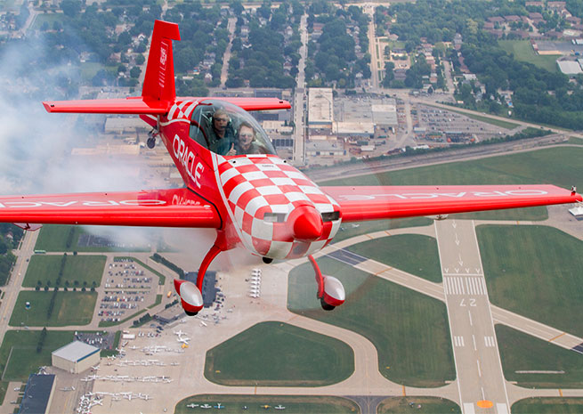 Sean D. Tucker flies with Aaron Wypyszynski over KOSH during EAA AirVenture.