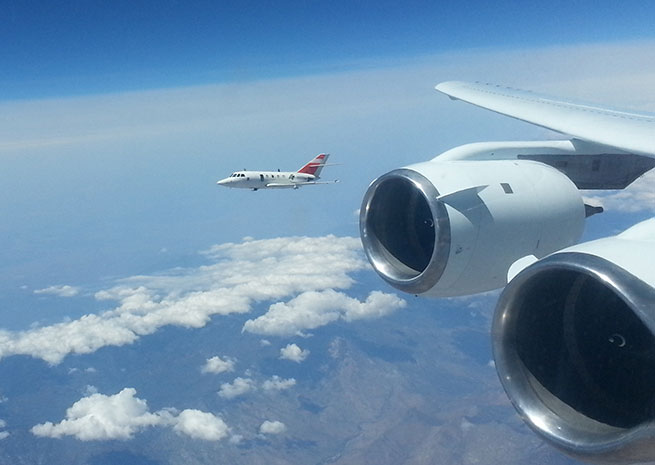 A DLR Falcon jet and a NASA DC-8 flew formation at various altitudes to test the DC-8’s emissions while burning biofuel. NASA photo. 