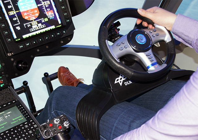 A steering wheel replaces the cyclic control, with an eight-way switch that allows reverse and lateral flight. The pedals control acceleration and deceleration. DLR photo. 