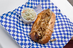 Diners at Flight Deck Grill can enjoy the “Rocket Brat,” is local bratwurst with either garlic-sauteed onions or sauerkraut. Photo by Mike Fizer.