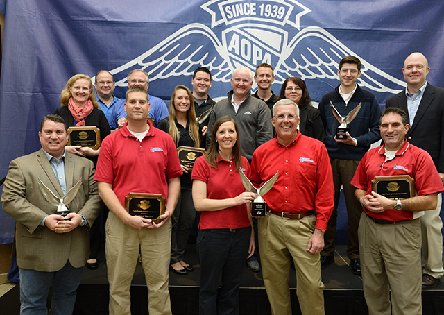 Winners of the 2015 Flight Training Excellence Awards presented by "Flight Training" magazine pose for a group photo after receiving plaques and trophies during a ceremony at AOPA headquarters in Frederick, Maryland, Dec. 2. Photo by David Tulis.
