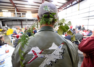 Flight instructor Daniel Wroe wears a sprig of greenery on his cap during the Tangier Island Holly Run breakfast at Chesapeake Sport Pilot in Stevensville, Maryland.