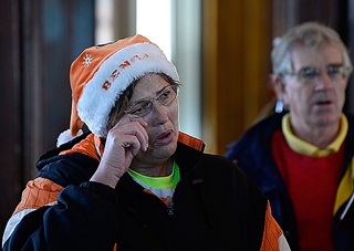 Carol Moore wipes a tear from her eye as she joins Tangier Island residents and visiting pilots singing “Silent Night” during a Swain Memorial United Methodist Church service.