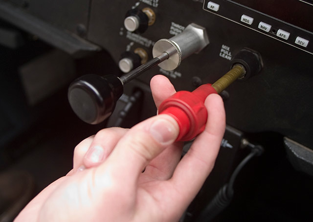 Here a pilot is adjusting the mixture-control knob in a Cessna 172.