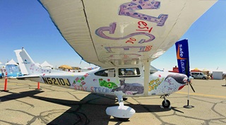 Children paint the Cessna 182 with water colors. Photo courtesy SafeLaunch.