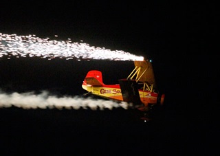 Gene Soucy pilots his “Showcat” biplane in the night show at EAA AirVenture 2012.
