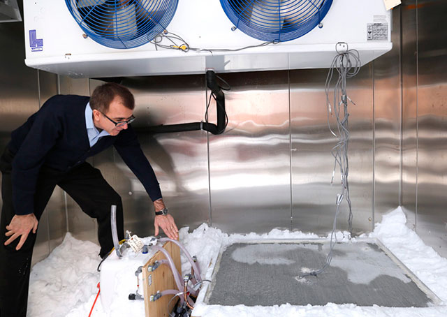 Halil Ceylan checks a test slab that uses heated pavement technology to melt snow and ice. One of the goals of the research project is to help smaller airports clear runways during winter storms. Photo by Christopher Gannon, courtesy of Iowa State University. 