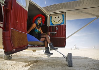 Pilot Ramona "SkyChick" Cox relaxes in her Cessna 206 which functions as transportation to and from the Burning Man festival and provides Cox with shelter during the week-long event. Photo by Chris Rose/AOPA