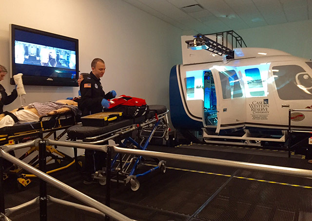 Flight nurse students diagnose SimMan before loading into the Redbird simulator.