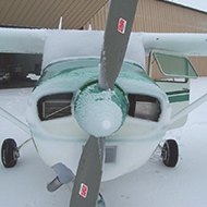 plane with a light snow cover on the wing and windshield