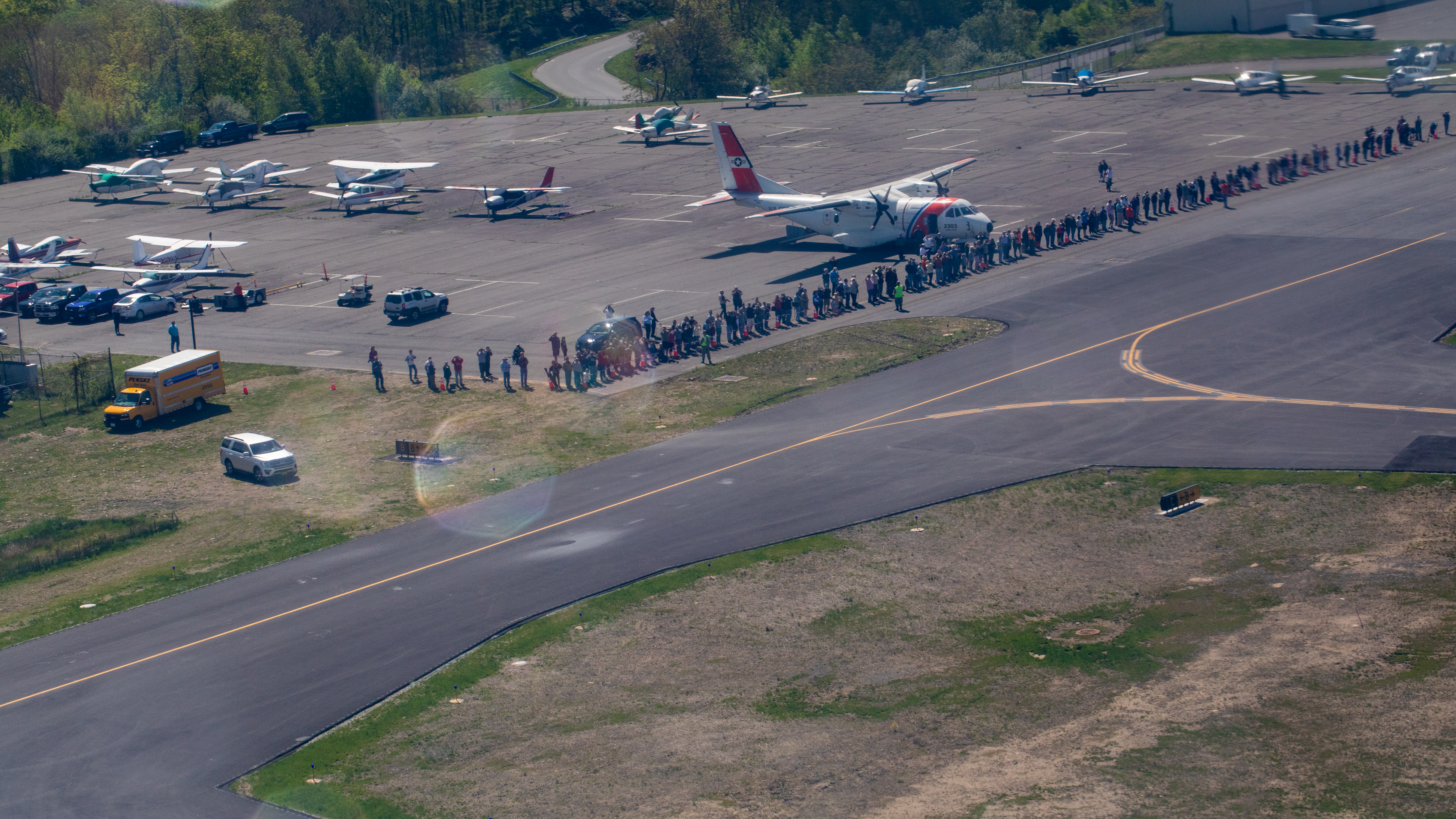 Specators watch the vintage airplanes of the D-Day Squadron depart for a flight to New York City May 18. Photo by Jim Moore.