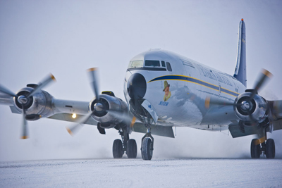 A DC–6 arrives at Anaktuvuk Pass, a native village, flown by First Officer Jeff Jackson and veteran Captain Ron Klemm. As Jackson emerged into the minus 63 deg. F wind chill, he questioned his career choice. Caribou graze on a hillside next to the dirt gravel runway, but often cross the runway to get at airport grass.